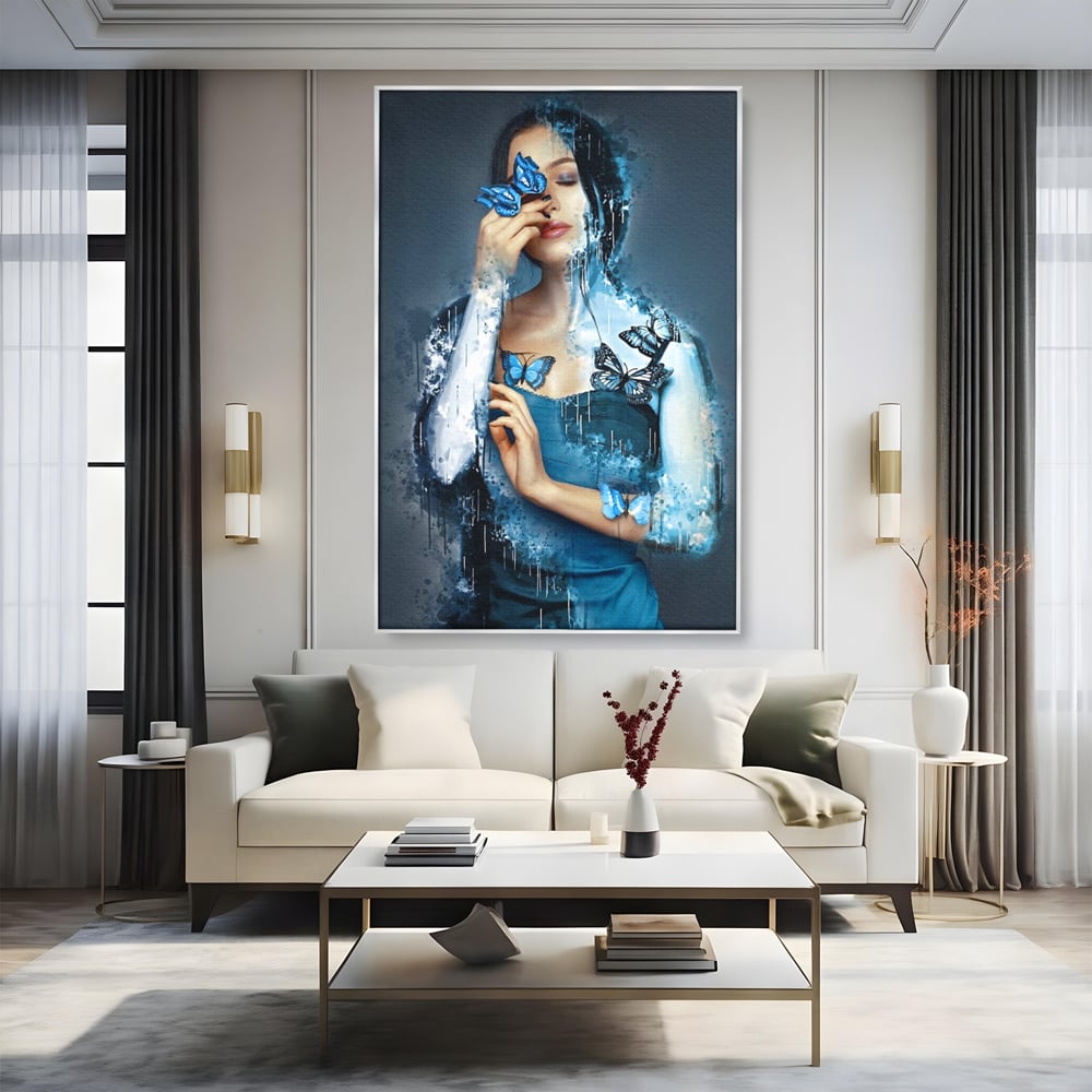 Tablou canvas cu portret feminin cu fluturi albastri, in rama de aluminiu argintiu, pe perete intr-un living